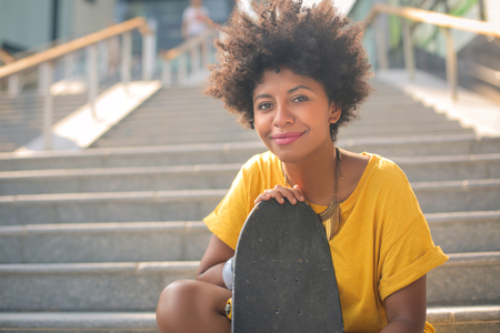 Skater girl is sitting on the stairsの写真素材