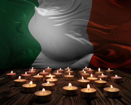 Mourning candles burning on Ireland national flag of background. Memorial weekend, patriot veterans day, National Day of Service & Remembrance. Burning candles on wooden surface. 3d illustration.の写真素材