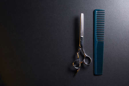 japanese professional hairdressers thinning scissors and comb on black background. Beauty salon equipment. Stylish Professional Barber, Haircut accessories.の写真素材