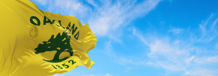 flag of Oakland, California at cloudy sky background on sunset, panoramic view. Patriotic concept about Oakland, California and copy space for wide banner. 3d illustration.の写真素材