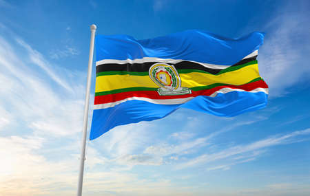 Minsk, Belarus - May, 2021: Flag of East African Community waving in the wind at flagpole on background of blue sky. 3d illustration.の写真素材