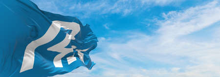 official flag of Ishikawa prefecture waving in the wind on flagpoles against sky with clouds on...