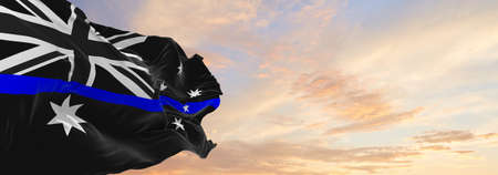 Thin Blue Line, Australia flag waving at cloudy sky background on sunset, panoramic view. copy space...