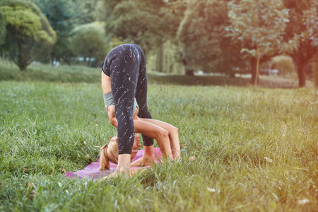 young Sport blond woman yogini practice yoga exercise in park on evening, sunset. yoga is meditation...