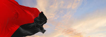 flag of Anarchism  at cloudy sky background on sunset, panoramic view. Anarchism symbol. copy space for wide banner. 3d illustrationの写真素材
