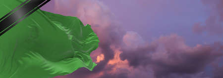 national flag of Libya with Mourning Ribbon. memory of victims of war, terrorist attack, coronavirus. Black funeral ribbon on flag Honoring memory of victims. 3D illustration.の写真素材