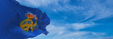 flag of Huelva , Spain at cloudy sky background on sunset, panoramic view. Spanish travel and patriot concept. copy space for wide banner. 3d illustrationの写真素材