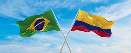 crossed national flags of Brazil  and Colombia flag waving in the wind at cloudy sky. Symbolizing relationship, dialog, travelling between two countries. Copy space. 3d illustrationの写真素材
