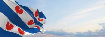 flag of Frisian , Netherlands at cloudy sky background on sunset, panoramic view. Dutch travel and...
