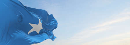 official flag of Somalia at cloudy sky background on sunset, panoramic view. patriot and travel concept. copy space for wide banner. 3d illustrationの写真素材