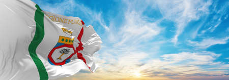 flag of Apulia, Italy at cloudy sky background on sunset, panoramic view. Italian travel and patriot concept. copy space for wide banner. 3d illustrationの写真素材