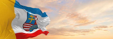 flag of Holy Cross Voivodeship, wojewodztwo swietokrzyskie , Poland at cloudy sky background on sunset, panoramic view. Polish travel and patriot concept. copy space for wide banner. 3d illustrationの写真素材