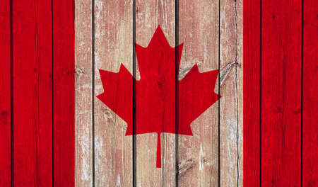 Top view of Old Painted Flag of Canada on Dark Wooden Fence, wall. patriot and travel concept. no flagpole. Plane design, layout. Flag backgroundの写真素材