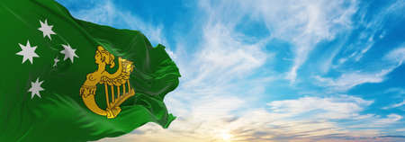 flag of Australian Irish heritage , Australia at cloudy sky background on sunset, panoramic view. Australian travel and patriot concept. copy space for wide banner. 3d illustrationの写真素材