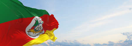 flag of Rio Grande do Sul , Brazil at cloudy sky background on sunset, panoramic view. Brazilian...