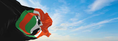 official flag of Arab-European League, Belgium at cloudy sky background on sunset, panoramic view....