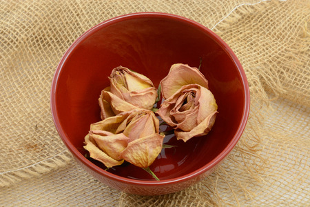 Dred roses in red bowlo n burlapの写真素材