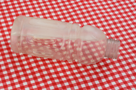 Reusable plastic drink bottle filled partially with water now frozen in preparation to keep a portable drink coldの写真素材