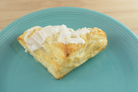 Apple turnover with frosting on blue plate