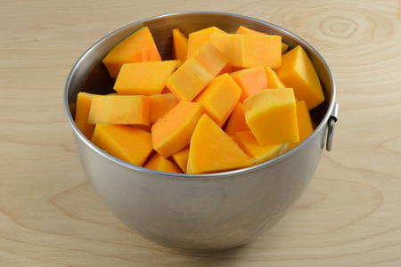 Raw uncooked butternut squash cubes in mixing bowl as cooking preparationの写真素材