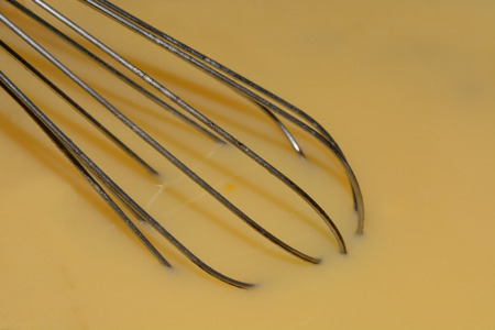 Close up of whisk mixing cheese sauceの写真素材