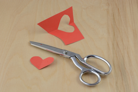 Valentine's Day crafting project with hearts with scissors and red construction paperの写真素材