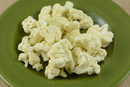 Close up of raw cauliflower florets on green plateの写真素材