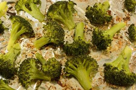 Close up of roasted broccoli florets sprinkled with garlic powder on aluminum foilの写真素材