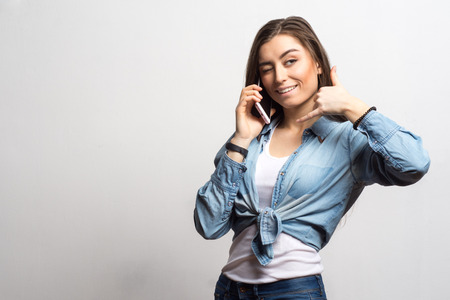 Portrait of a young smiling happy woman talking on a mobile phone. Lifestyle, people and technology concept.の写真素材