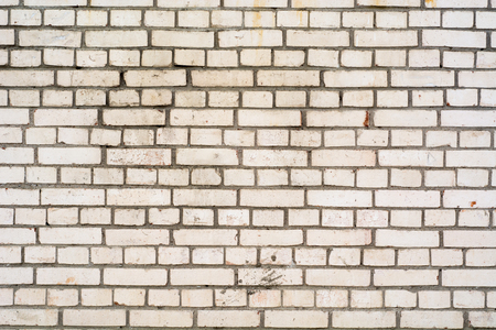 Background of the damaged old brick wall with horizontal masonryの写真素材
