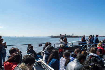New York, NY / USA - March 2016: People on a cruise tour to Ellis Island and Statue of Liberty in early springのeditorial素材