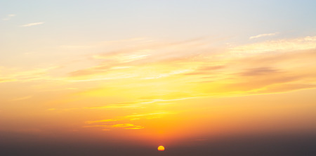 Fiery orange summer dramatic sunset or sunrise cloudscape with setting sun.の写真素材