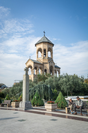 Tbilisi, Georgia - October 2018: people sitting on the bench in the territory of the Holy Trinity...