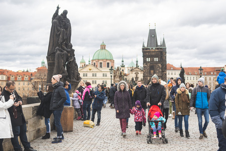Prague, Bohemia  Czech Republic - December 2018: Tourists walking on the famous Charles Bridge (Karluv most) on cloudy winter day, statues and dramatic sky, selective focusのeditorial素材