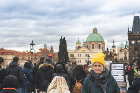 Prague, Bohemia  Czech Republic - December 2018: Tourists walking on the famous Charles Bridge (Karluv most) on cloudy winter day, statues and dramatic skyのeditorial素材