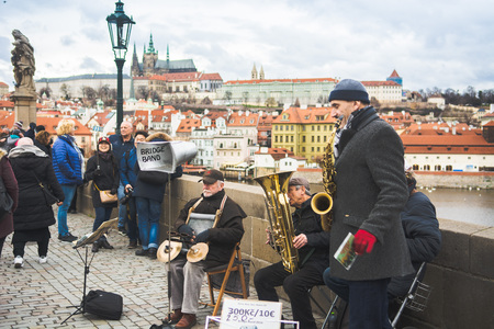 Prague, Bohemia, Czech Republic - December 2018: A musical jazz band playing on the famous Charles bridge, tourist walking around and listeningのeditorial素材