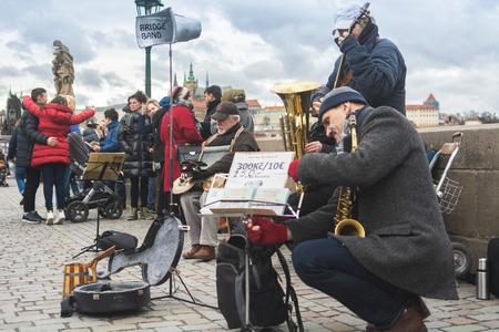 Prague, Bohemia, Czech Republic - December 2018: A musical jazz band playing on the famous Charles bridge, tourist walking around and listeningのeditorial素材