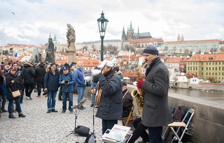 Prague, Bohemia, Czech Republic - December 2018: A musical jazz band playing on the famous Charles bridge, tourist walking around and listeningのeditorial素材