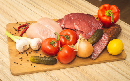 Wooden boars with composed fresh vegetables and raw meat and spicesの写真素材
