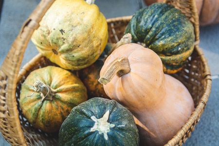 Autumn rustic still life - different colourful pumpkins in a basket, selective focus.の写真素材
