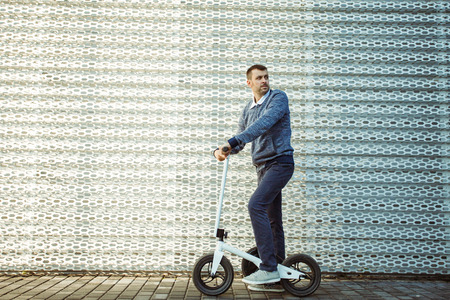 Man pushing scooter on embankmentの写真素材