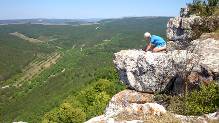 Brave boy on the hand of mountainの写真素材