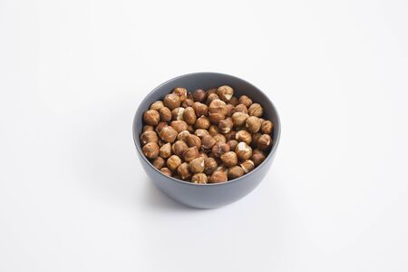 Hazelnut nuts in bowl, isolated on white backgroundの写真素材