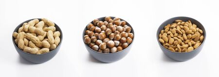 Peanuts, hazelnuts and almonds nuts in bowl, isolated white background
