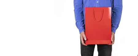 red and black colored gift package standing in man's hand, isolated background.の写真素材