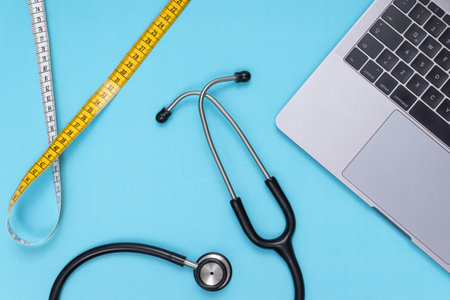 black stethoscope, laptop, tape measure, blue isolated backgroundの写真素材