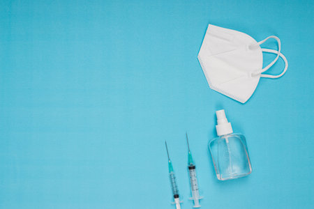 disinfectant, needle, vaccine, mask standing on blue backgroundの写真素材