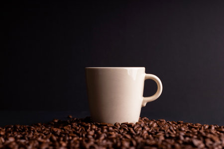 a coffee mug among coffee beans, black isolated backgroundの写真素材
