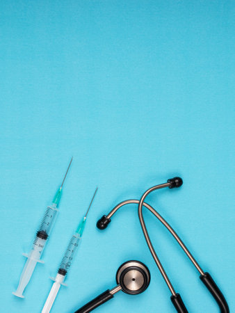 stethoscope, needle, vaccine standing on blue backgroundの写真素材