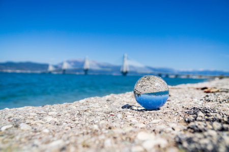Rio-Antirro Bridge in background. Focus is on crystal ball in foregroundの写真素材